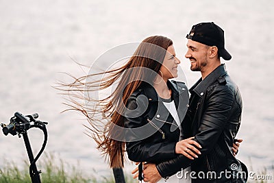 Portrait of a couple sitting near electric scooters, enjoying time in nature together, Two lovers on electric scooters.People on Stock Photo