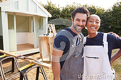 Portrait Of Couple Taking A Break From Building Outdoor Summerhouse In Garden Stock Photo