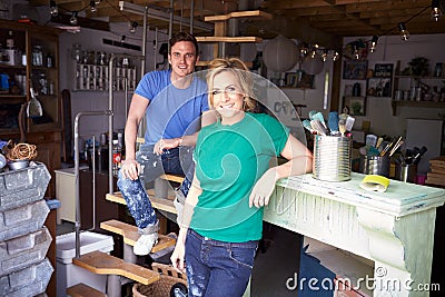 Portrait Of Couple In Workshop Upcycling And Working On Fire Surround Stock Photo