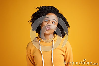 Portrait of crazy african american young woman with beautiful smile dressed in casual clothes over yellow background. Stock Photo