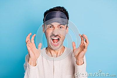 Portrait of crazy aggressive brunet guy wearing eye mask shouting bad mood isolated over bright blue color background Stock Photo
