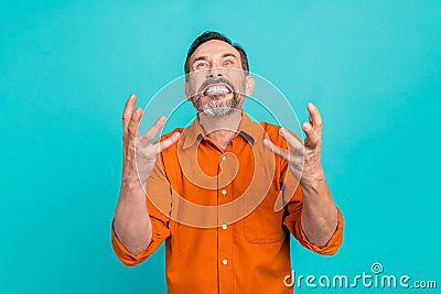 Portrait of crazy mad furious man with gray beard dressed orange shirt clenching teeth in anger isolated on turquoise Stock Photo