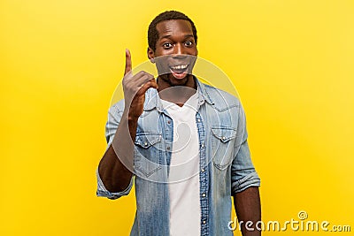 Portrait of creative inspired man pointing finger up, showing great idea sign. studio shot isolated on yellow background Stock Photo