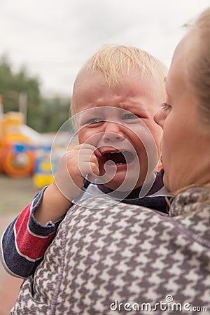 Portrait of a crying little boy who is being held Stock Photo