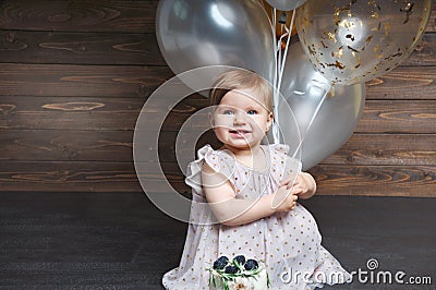 Portrait of cute adorable baby girl celebrating her first birthday with cake and balloons Stock Photo