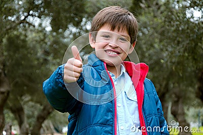 Portrait of a cute blond-haired boy, thumbs up and smile Stock Photo