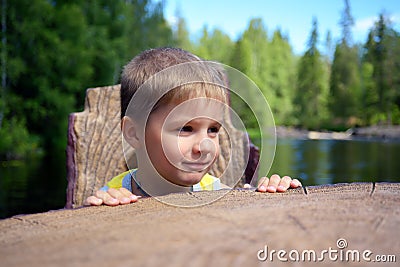 Portrait of a cute boy sits chair near edge of a river Stock Photo