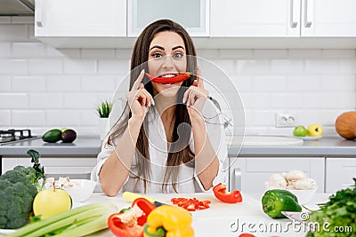 Cute Girl Playing Fool and Biting a Chili Pepper Stock Photo