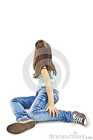 Portrait of a cute girl sitting on the floor, looking up on wall Stock Photo