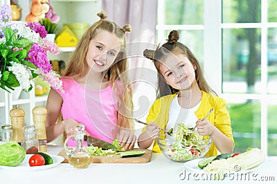 Portrait of cute girls preparing delicious fresh salad Stock Photo