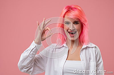 Smiling pleased young woman showing a ring gesture Stock Photo