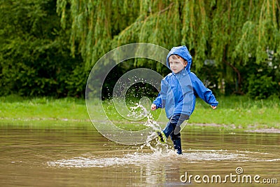 Portrait of cute kid boy playing with handmade ship. kindergarten boy sailing a toy boat by the waters` edge in the park Stock Photo