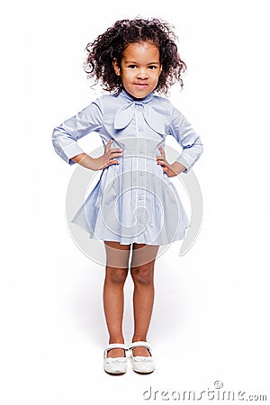 Portrait of a cute little african american girl in a blue dress, isolated on white background. Stock Photo