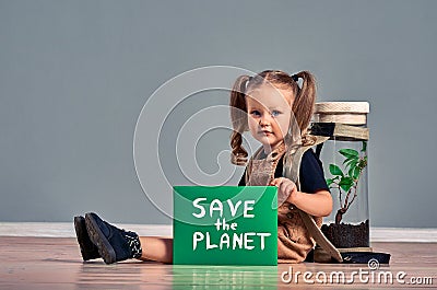 Portrait of cute little girl holding SAVE THE PLANET sign and looking at camera while protesting for nature, copy space Stock Photo