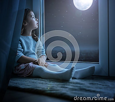 Portrait of a cute little girl looking at the night moon Stock Photo