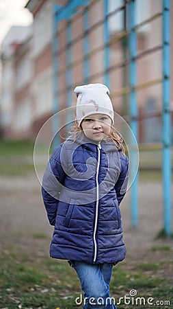 Portrait of cute little girl in white hat on playground near swedish ladder Stock Photo