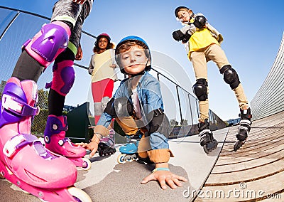 Cute boy in roller skates having fun with friends Stock Photo