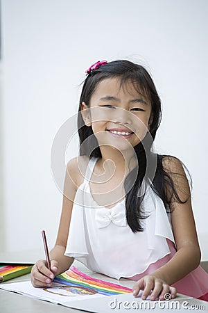 Portrait of cute schoolgirl smiling while reading Stock Photo