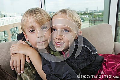 Portrait of cute siblings in dinosaur and vampire costumes at home Stock Photo