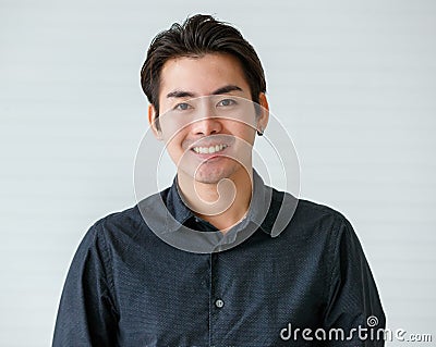 Portrait of a cute young and handsome Asian man in casual shirt pose to camera with warm smile and self trust Stock Photo