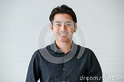 Portrait of a cute young and handsome Asian man in casual shirt pose to camera with warm smile and self trust Stock Photo