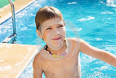 The portrait of cutest boy of six years old with toy necklace at swimming pool outdoor Stock Photo