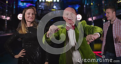 Portrait d'homme caucasien supérieur gay et jolie jeune femme danser à la discothèque et de regarder la caméra. Vieux joyeux clips vidéos Portrait d'homme caucasien supérieur gay et jolie jeune femme danser à la discothèque et de regarder la caméra. Vieux joyeux clips vidéos