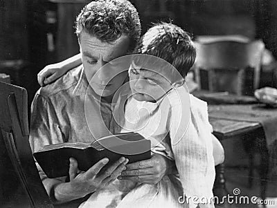 Portrait of dad reading bedtime story to son Stock Photo