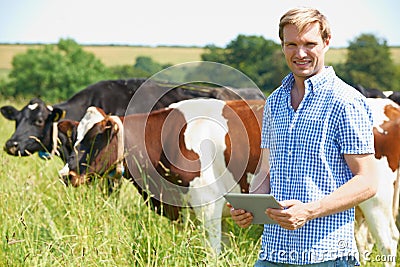 Portrait Of Dairy Farmer With Digital Tablet In Field Stock Photo