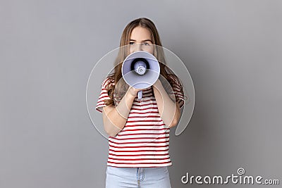 Little girl screaming in megaphone, speaking, announcing important information. Stock Photo