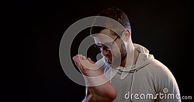 A portrait of a dark-haired man with a middle-aged beard, in front of him is someone`s foot, which he kneads and kisses Stock Photo