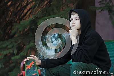 Portrait of daydreaming teenage skateboarder looking ahead Stock Photo