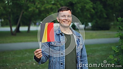 Portrait de mouvement lent de type émotif avec le visage expressif ondulant le drapeau belge, regardant l'appareil-photo et le so clips vidéos Portrait de mouvement lent de type émotif avec le visage expressif ondulant le drapeau belge, regardant l'appareil-photo et le so clips vidéos