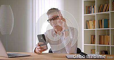 Portrait de plan rapproché du jeune homme d'affaires caucasien bel en verres prenant des selfies au téléphone souriant gaiement banque de vidéos Portrait de plan rapproché du jeune homme d'affaires caucasien bel en verres prenant des selfies au téléphone souriant gaiement banque de vidéos