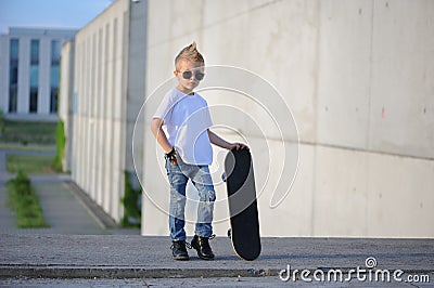 A portrait of defiant boy with skateboard outdoors. Stock Photo