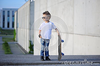 A portrait of defiant boy with skateboard outdoors. Stock Photo