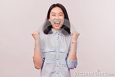 Portrait delighted girl raising fists shouting yes Stock Photo