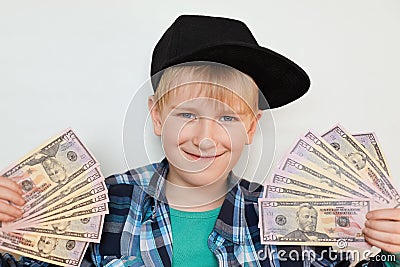 A portrait of delighted little stylish boy in black cap holding money in his hands. A happy child male holding cash isolated over Stock Photo