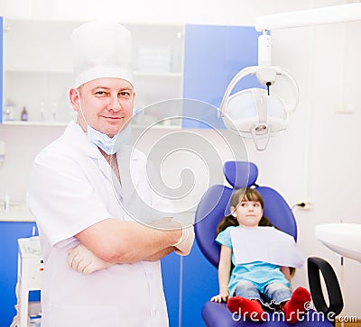 Portrait dentist with patient in the background. l Stock Photo