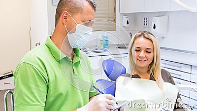 Closeup portrait of dentist writes prescription to his patient Stock Photo