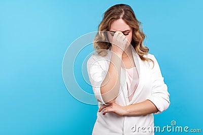 Portrait of depressed dramatic woman crying rubbing eyes, feeling desperate and hopeless. blue background Stock Photo