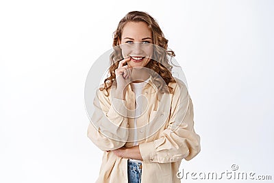 Portrait of determined attractive girl with blond hair, smiling satisfied and confident, looking at camera assertive Stock Photo