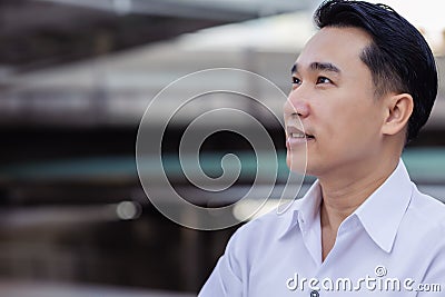 Portrait determined business man Handsome asian businessman looks away to copy space in city Asian adult guy get happy with smile Stock Photo