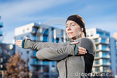 Portrait of a determined young woman stretching her left arm Stock Photo