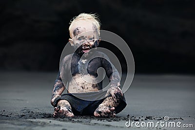 Portrait of dirty child on the black san beach Stock Photo