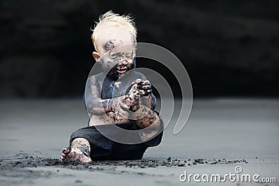 Portrait of dirty child on the black san beach Stock Photo