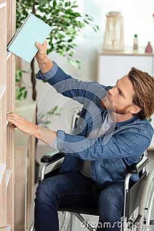 portrait disabled student in wheelchair choosing books Stock Photo