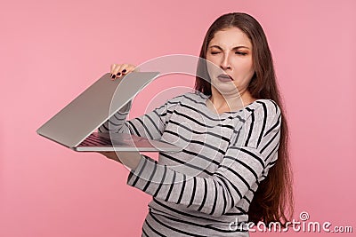 Portrait of displeased girl in striped sweatshirt closing laptop, looking with suspicious and distrust at screen Stock Photo