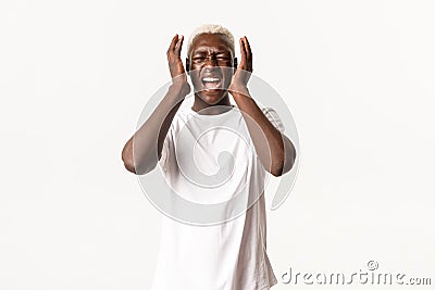 Portrait of distressed african-american panicking man, gasping and looking alarmed, crying and shaking hands desperate Stock Photo