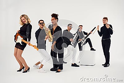 Portrait of diverse group of young people musical band playing with instruments - isolated on white background. Stock Photo